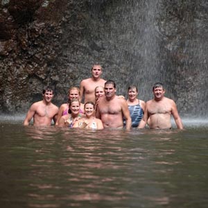 kayakers group under waterfall
